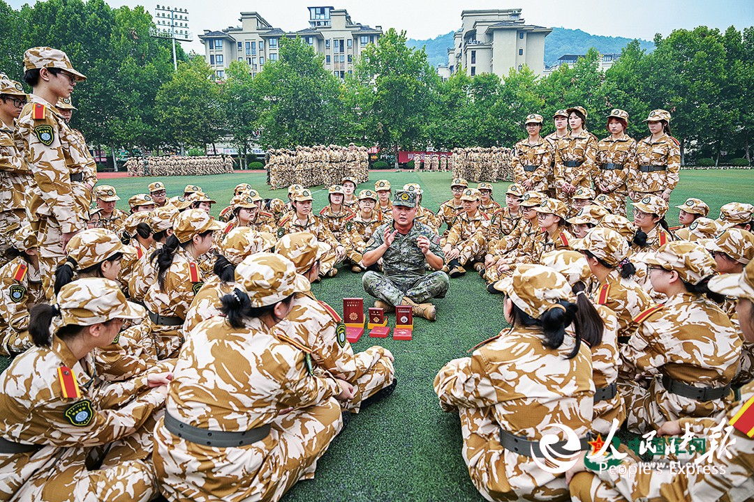 武警重庆总队机动支队为驻地高校开展军训时，穿插组织国防教育活动。图为一级上士安俊吉为学生们讲述所获奖章、纪念章背后的故事。本报特约通讯员  王  肸摄