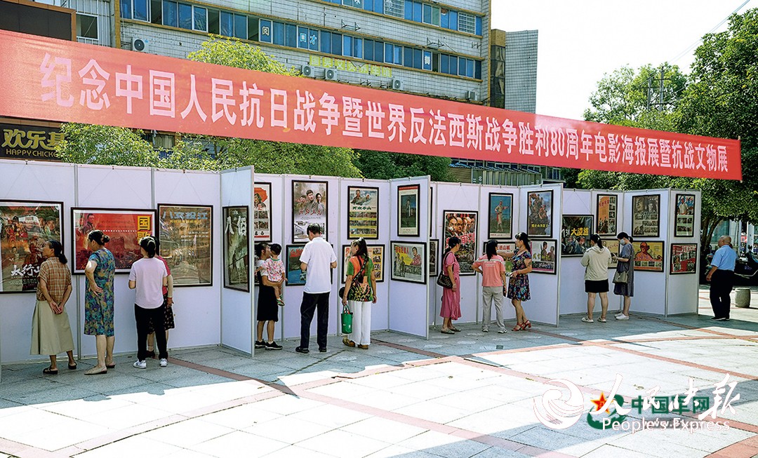 江西省上高县举办纪念中国人民抗日战争暨世界反法西斯战争胜利80周年电影海报展暨抗战文物展，市民驻足观展。邝小文摄